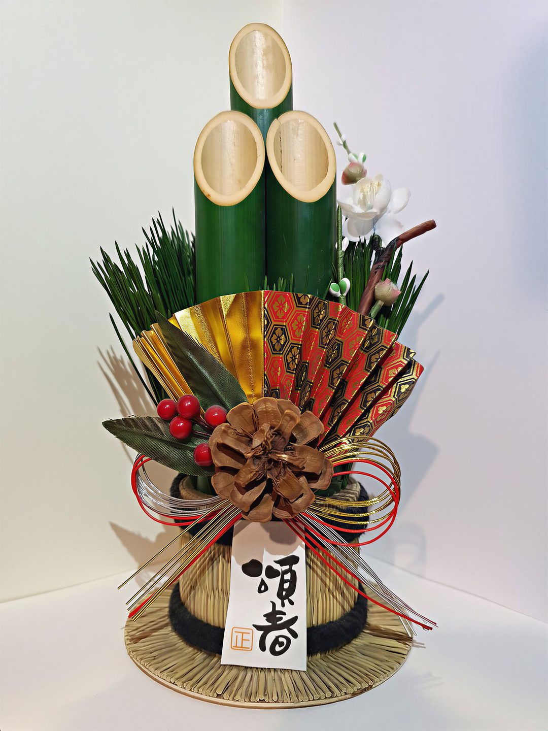 A kadomatsu, a New Year arrangement of bevel-cut bamboo and pine branches, standing beside a doorway