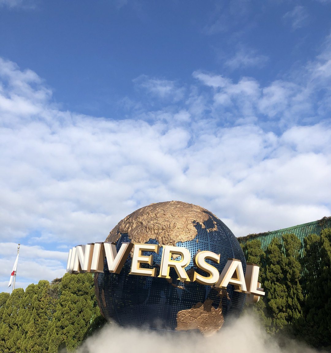 Le globe Universal et son enseigne, à l'entrée du parc, sous un ciel bleu