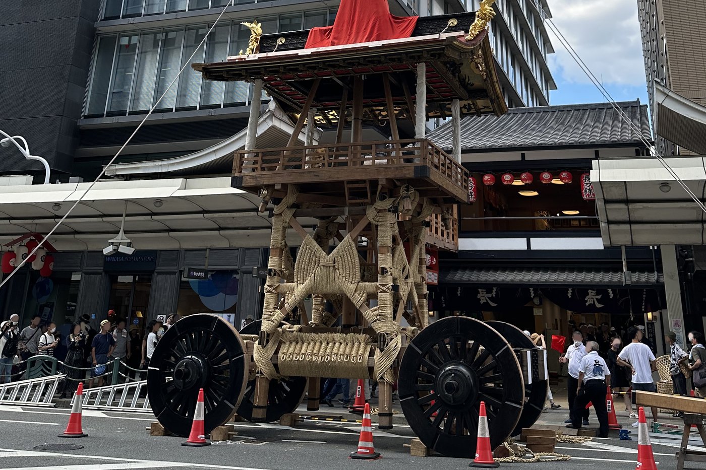 Char Naginata-hoko du Gion Matsuri tiré de jour dans les rues de Kyoto, immeubles modernes en arrière-plan.