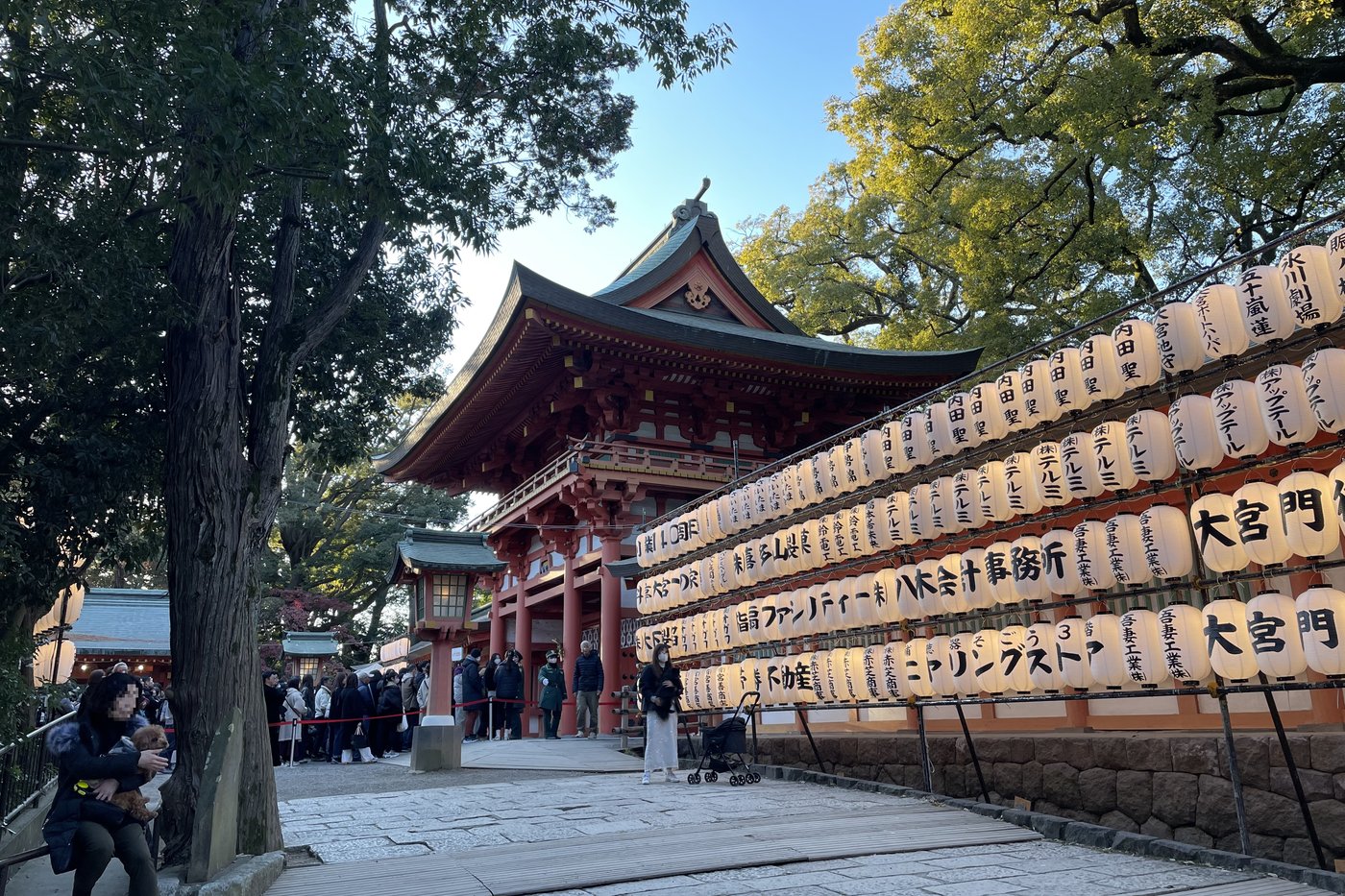 Foule devant le sanctuaire Hikawa à Ōmiya pour le hatsumōde, lanternes suspendues au portique.