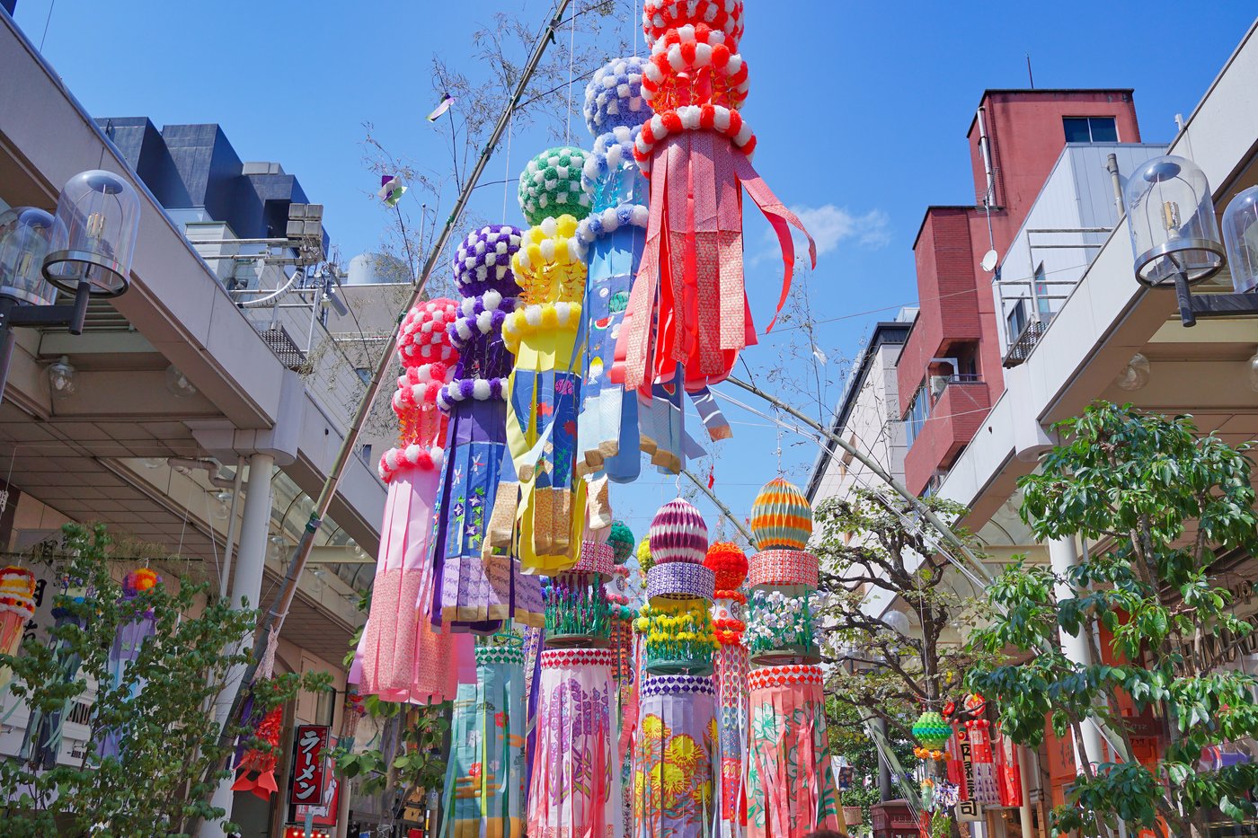 Guirlandes de papier colorées du Tanabata de Sendai suspendues au-dessus d'une rue commerçante.