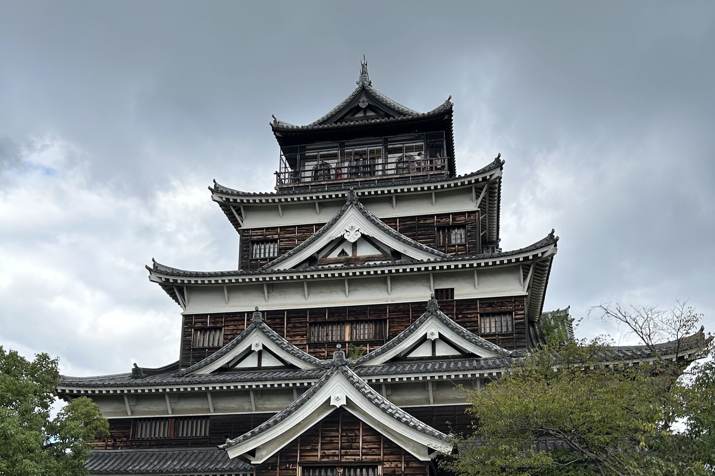 The rebuilt keep of Hiroshima castle, surrounded by trees.
