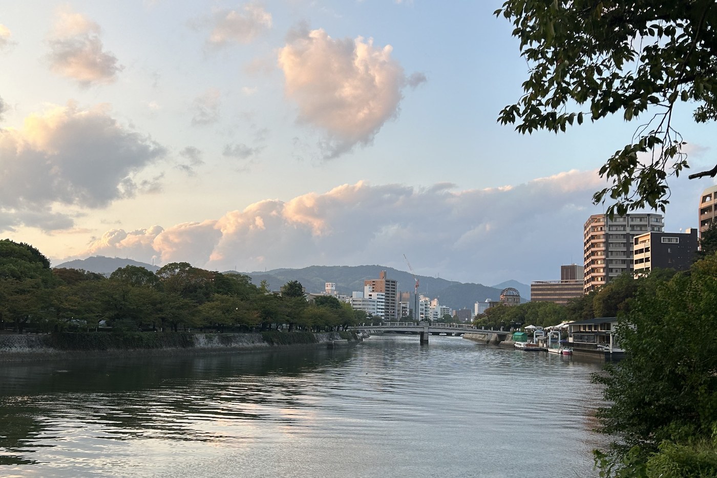 The Motoyasu river in Hiroshima at dusk, the outline of the Genbaku Dome visible in the distance.