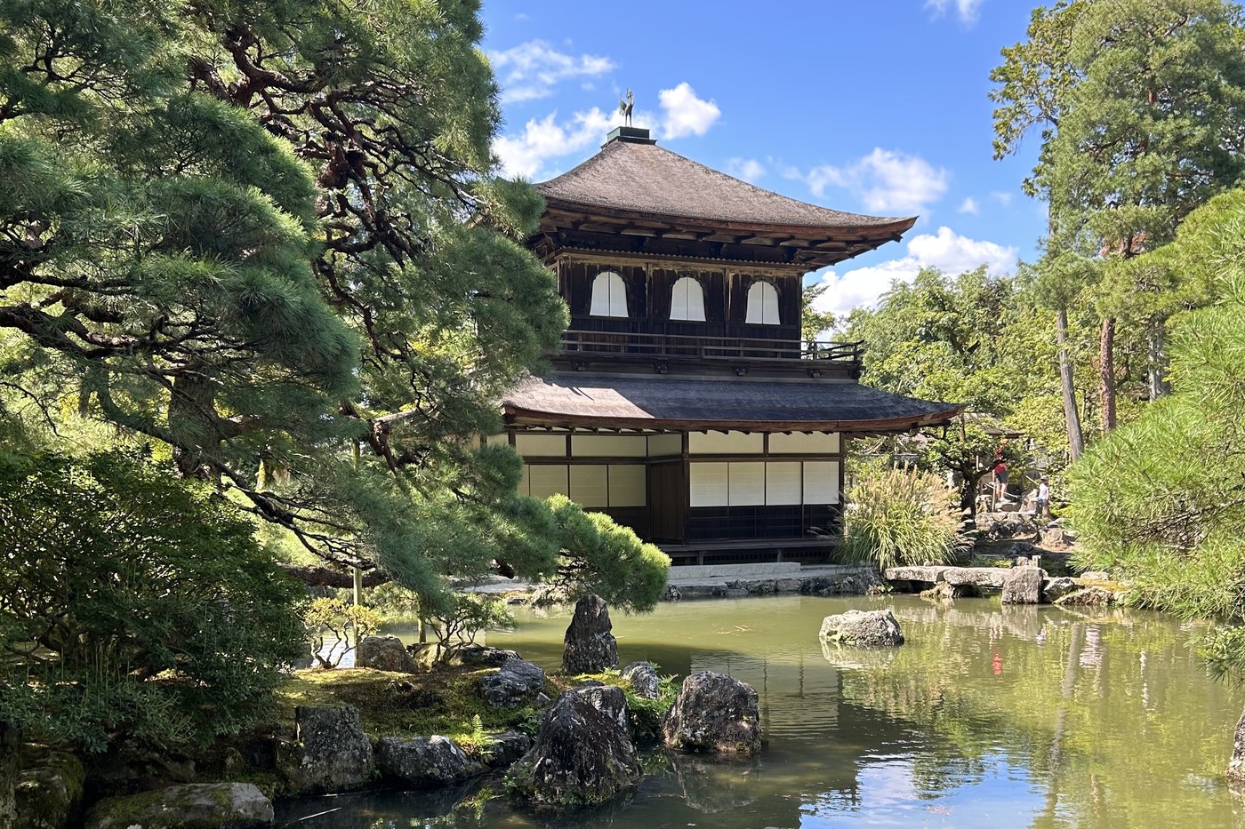 The Silver Pavilion (Ginkaku-ji) reflected in its pond, ringed by pines, in Kyoto.