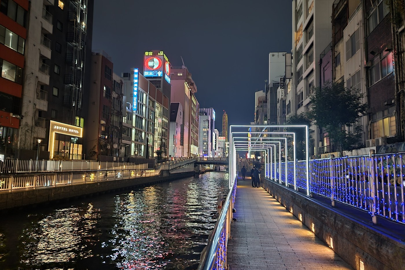 The Dotonbori canal in Osaka at night, lit buildings reflected in the water.