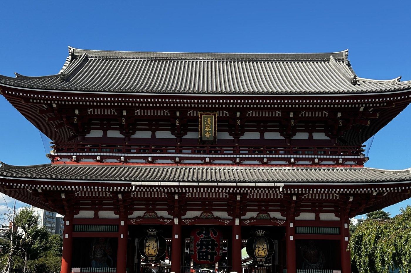 The Hozomon gate of Sensoji temple in Asakusa, Tokyo, under a blue sky.
